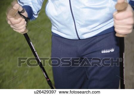 Stock Photo - Male Nordic walker, close up of hands and pole straps. Fotosearch
