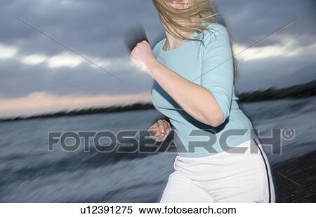 Upper part of woman's body jogging at the beach, side view View Large Photo Image Stock Photography - Upper part of woman's body jogging at the beach, side view. Fotosearch