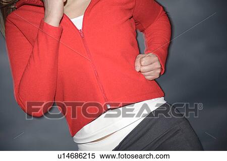 Stock Photography - Upper part of woman's body jogging at the beach, front view. Fotosearch