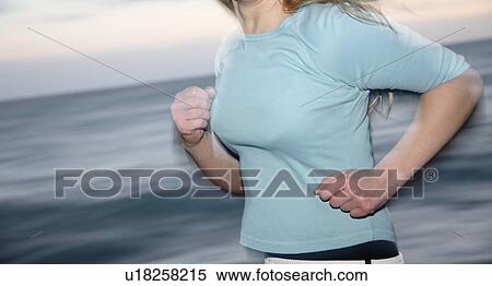 Upper part of woman's body jogging at the beach, side view View Large Photo Image Stock Photography - Upper part of woman's body jogging at the beach, side view. Fotosearch