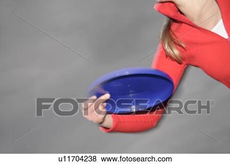 Woman playing with a frisbee, throwing and catching, in front of dark clouds View Large Photo Image Stock Photo - Woman playing with a frisbee, throwing and catching, in front of dark clouds. Fotosearch