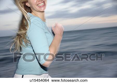 Young blond woman jogging at the beach, side view View Large Photo Image Picture - Young blond woman jogging at the beach, side view. Fotosearch