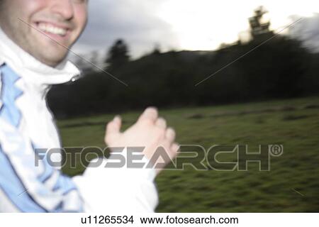 Picture - Young man jogging in spite of bad weather. Fotosearch