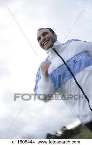 Picture - Young man jogging in spite of bad weather. Fotosearch