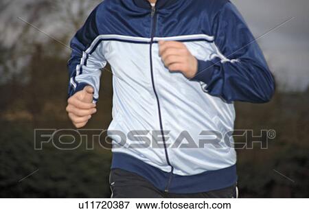 Stock Photo - Young man jogging in spite of bad weather. Fotosearch