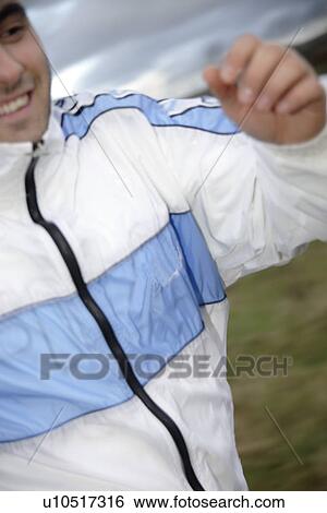 Stock Photograph - Young man jogging in spite of bad weather. Fotosearch