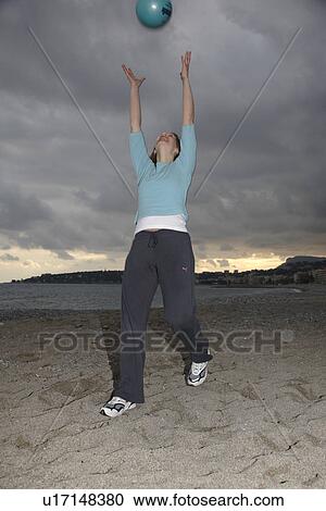 Young woman playing with a ball at the beach View Large Photo Image Stock Image - Young woman playing with a ball at the beach. Fotosearch