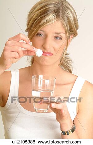 Woman dropping fizzy tablet into water, disgusted View Large Photo Image Stock Photo - Woman dropping fizzy tablet into water, disgusted. Fotosearch