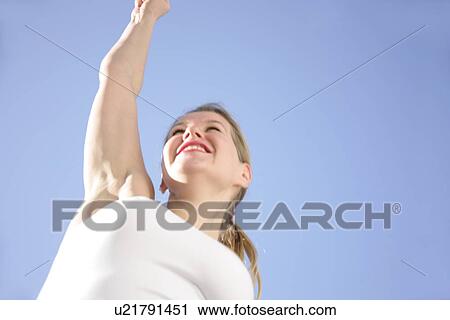 Young woman with long blond hair running at the beach, worm's eye view View Large Photo Image Stock Image - Young woman with long blond hair running at the beach, worm's eye view. Fotosearch