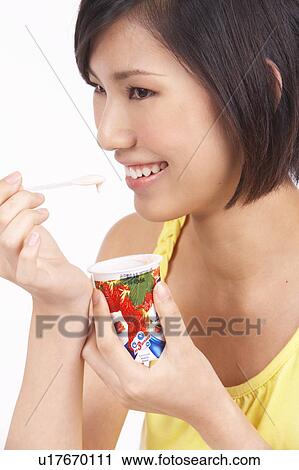 Stock Image - Portrait of Natural Young girl Eating Yoghurt, Close-Up, Portrait. Fotosearch