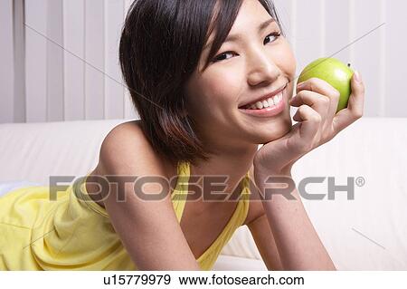 Portrait of Natural Young girl holding Apple, Smiling View Large Photo Image Stock Photo - Portrait of Natural Young girl holding Apple, Smiling. Fotosearch