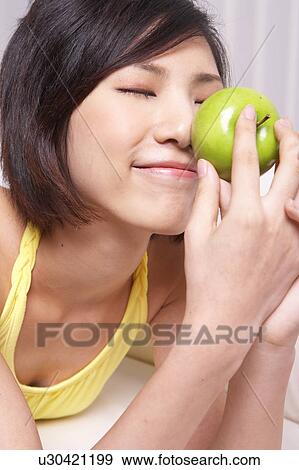 Portrait of Natural Young girl holding Apple, Smiling View Large Photo Image Stock Photo - Portrait of Natural Young girl holding Apple, Smiling. Fotosearch