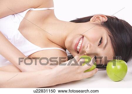 Portrait of Natural Young girl lying on Floor, Holding Apple View Large Photo Image Stock Image - Portrait of Natural Young girl lying on Floor, Holding Apple. Fotosearch