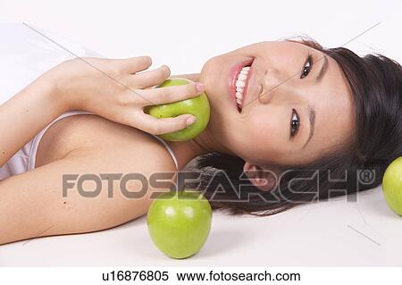 Portrait of Natural Young girl lying on Floor, Holding Apple View Large Photo Image Stock Photography - Portrait of Natural Young girl lying on Floor, Holding Apple. Fotosearch