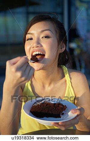 Picture - Young Lady Eating Cake. Fotosearch