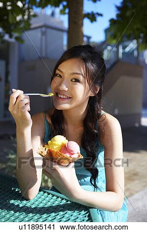 Stock Image - Young Lady Eating Ice-Cream. Fotosearch