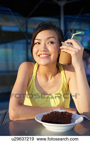 Young Lady Holding Cold Drink Against Face, Looking Away View Large Photo Image Stock Photo - Young Lady Holding Cold Drink Against Face, Looking Away. Fotosearch