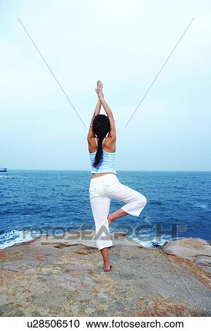 Young woman doing yoga, facing the sea View Large Photo Image Stock Image - Young woman doing yoga, facing the sea. Fotosearch