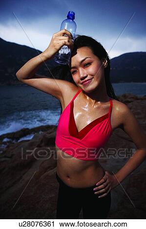 Young woman in sporty wear, standing near the sea, front view View Large Photo Image Stock Image - Young woman in sporty wear, standing near the sea, front view. Fotosearch