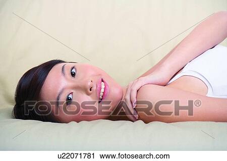 Young woman lying on sofa View Large Photo Image Stock Image - Young woman lying on sofa. Fotosearch