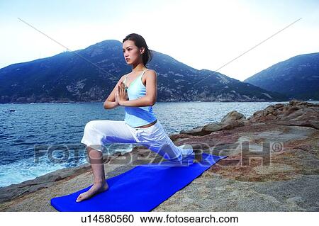 Young woman practising yoga on exercise mat, near the sea View Large Photo Image Stock Image - Young woman practising yoga on exercise mat, near the sea. Fotosearch