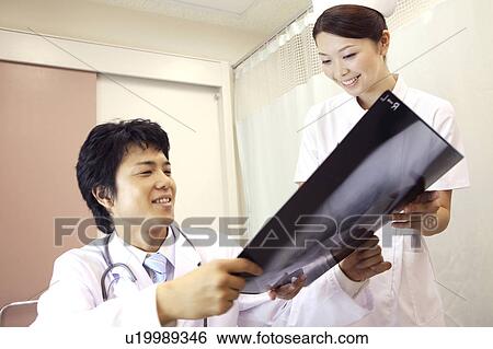 Doctor and nurse looking at X-ray View Large Photo Image Stock Photograph - Doctor and nurse looking at X-ray. Fotosearch