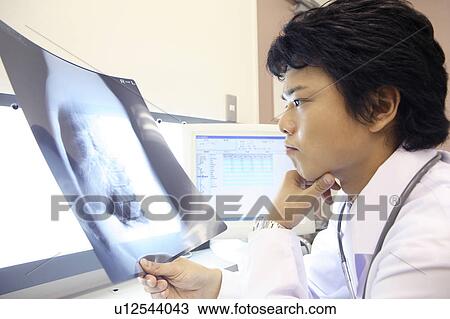 Stock Image - Doctor looking at X-ray. Fotosearch