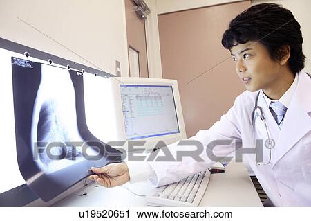 Stock Image - Doctor looking at X-ray. Fotosearch