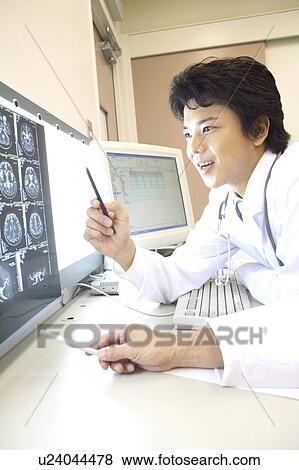 Doctor looking at X-ray View Large Photo Image Stock Photo - Doctor looking at X-ray. Fotosearch