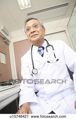 Doctor sitting a chair View Large Photo Image Stock Image - Doctor sitting a chair. Fotosearch