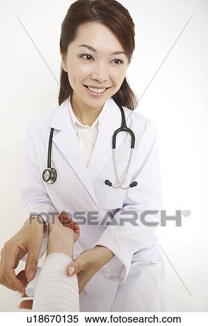 Doctor winding up a bandage View Large Photo Image Stock Photography - Doctor winding up a bandage. Fotosearch