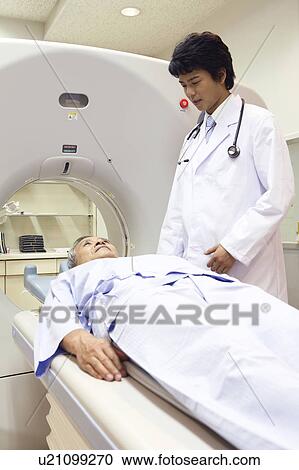 Stock Image - Man examined by a CT scanning. Fotosearch