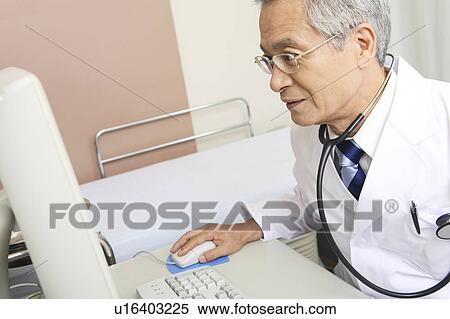 Stock Photography - Physician operating a PC. Fotosearch