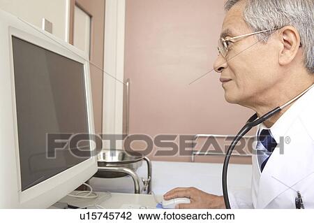 Stock Image - Physician watching a monitor. Fotosearch