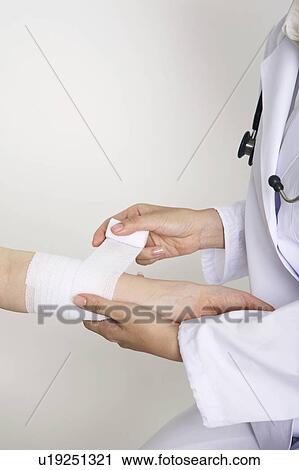 Hands winding up a bandage View Large Photo Image Stock Image - Hands winding up a bandage. Fotosearch