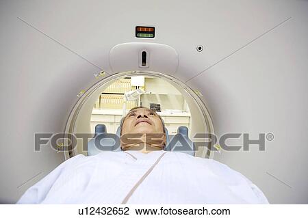 Stock Image - Man examined by a CT scanning. Fotosearch