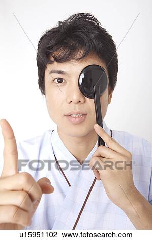 Stock Image - Man taking an eye test. Fotosearch