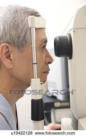 Stock Photo - Man taking an eye test. Fotosearch