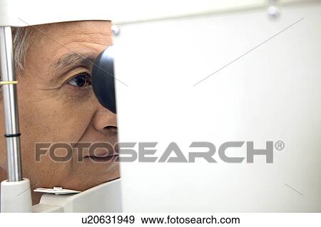 Man taking an eye test View Large Photo Image Stock Photo - Man taking an eye test. Fotosearch