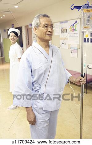 Picture - Man walking with intravenous feeding. Fotosearch