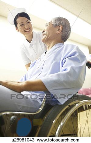 Stock Image - Nurse and the patient of the wheelchair. Fotosearch