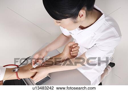 Stock Image - Nurse collecting blood. Fotosearch