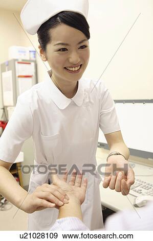 Stock Photo - Nurse measuring a pulse. Fotosearch