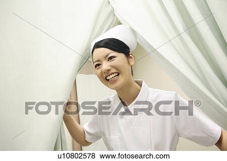 Stock Photo - Nurse opening a curtain. Fotosearch