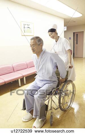 Stock Photo - Nurse pushing the wheelchair. Fotosearch