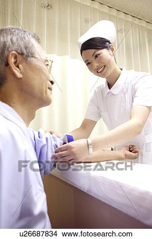 Picture - Nurse rolling up the arm of the patient. Fotosearch