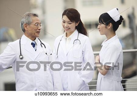 Doctor and nurse having a chat View Large Photo Image Stock Photography - Doctor and nurse having a chat. Fotosearch