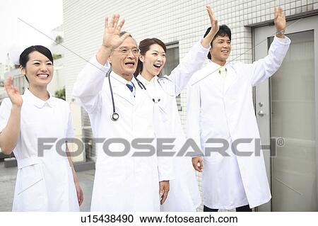 Stock Image - Doctor and nurse who wave hand. Fotosearch