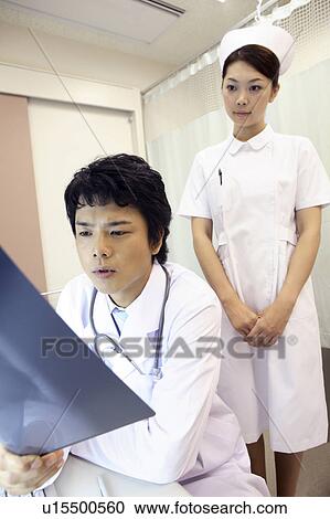 Doctor looking at X-ray View Large Photo Image Stock Image - Doctor looking at X-ray. Fotosearch