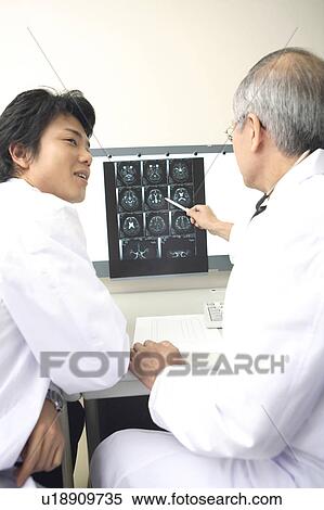 Doctor looking at X-ray View Large Photo Image Stock Photography - Doctor looking at X-ray. Fotosearch